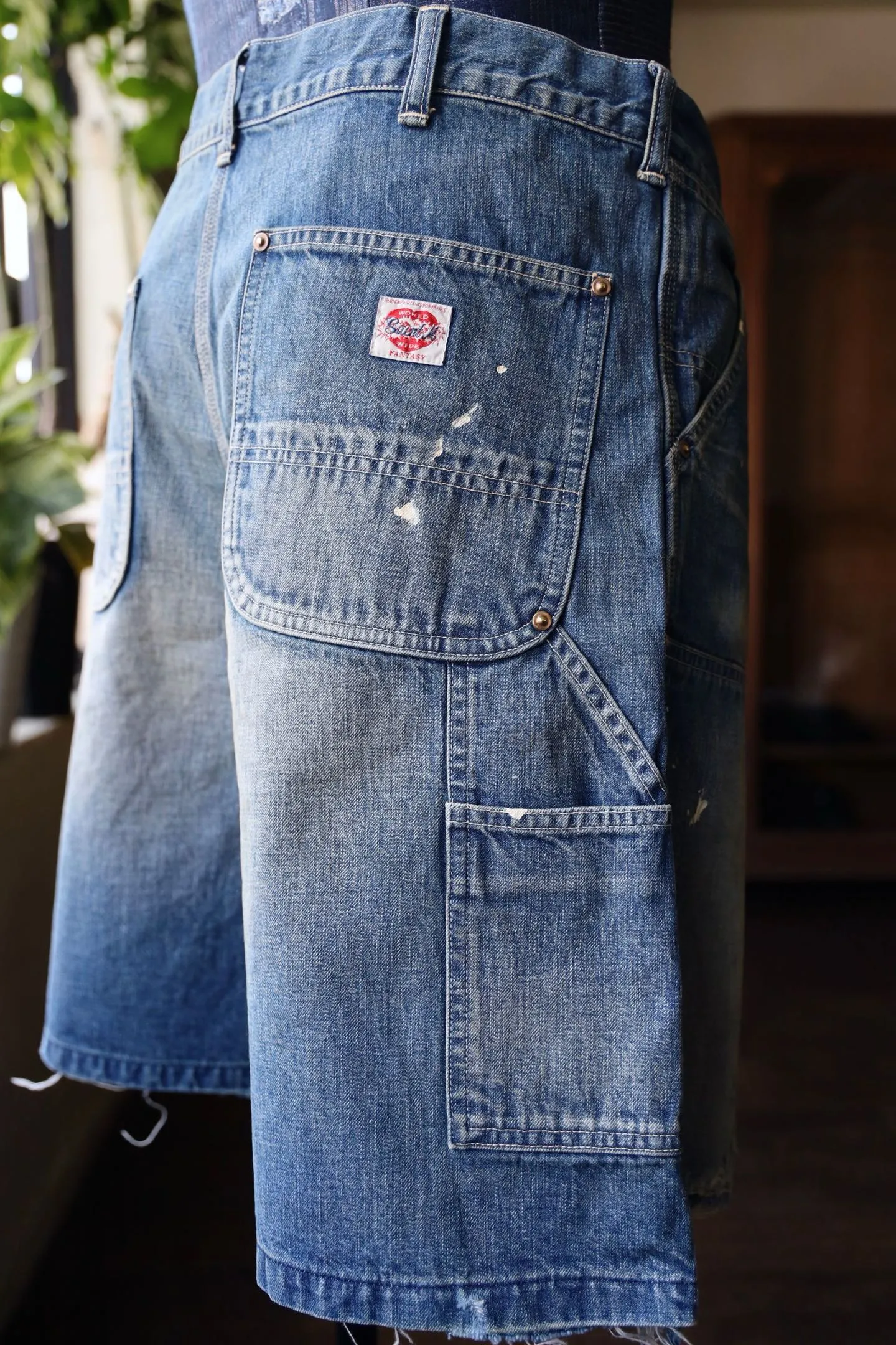 SAINT Mxxxxxx DOUBLE KNEE SHORTS/BLU Knee patches splashed with ink and water-splashed denim shorts. Denim blue S-XL. Custom-woven and dyed denim fabric with clear texture. Heavy-wash water-fading treatment to create local mottled fading/hole effects. Artificial distressing to simulate natural wearing marks. VINTAGE sense. Original consistent damage treatment. Hand-splashed ink and paint. Original consistent wash mark/pocket mark. Double knee patch. Rivet reinforcement. Improve functionality while enhancing design